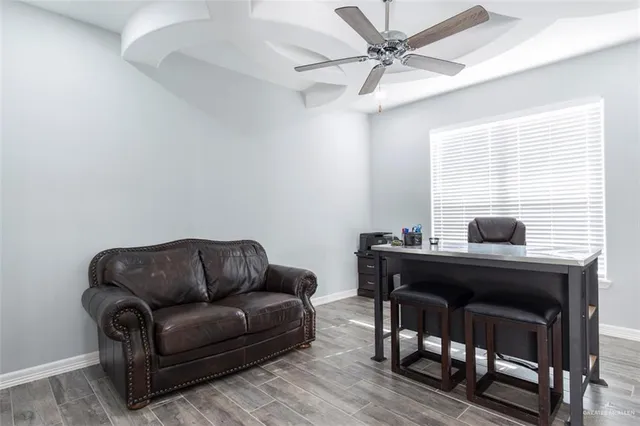 a living room with furniture a ceiling fan and a window