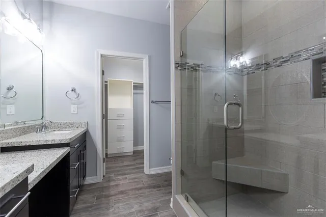 a bathroom with a granite countertop sink a shower and a mirror