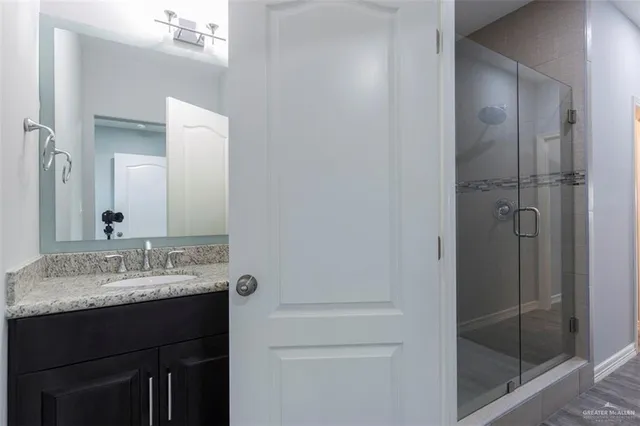 a bathroom with a granite countertop sink and a mirror