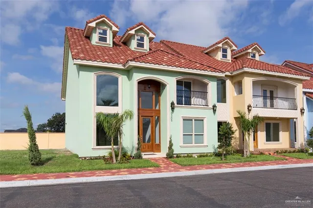 front view of a brick house with a yard