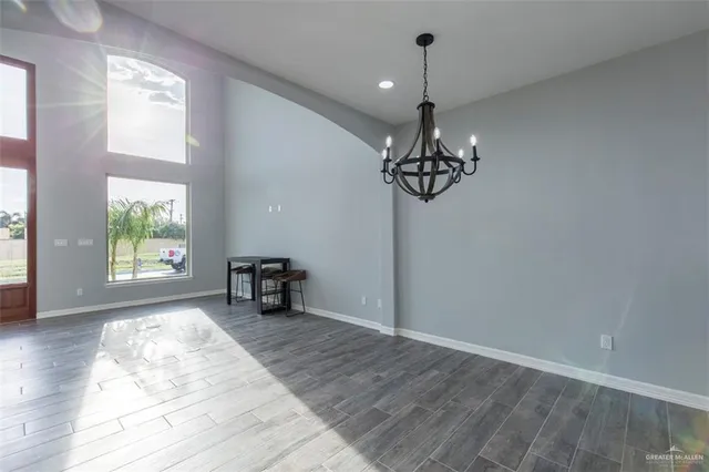 an empty room with windows and chandelier