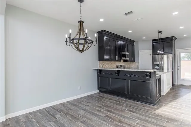 a large kitchen with a sink and dishwasher a refrigerator with wooden floor