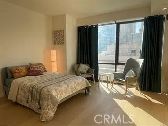 a bedroom with a bed chair and a large window