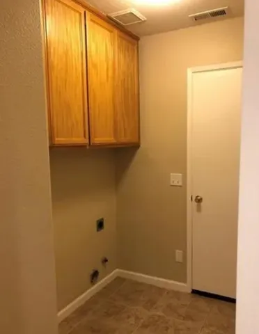 a backyard of a house with plants and large tree