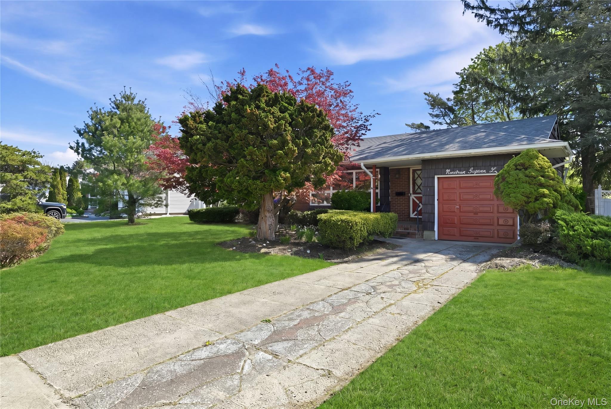 19 Gaymor Lane Commack, NY 11725 - Photo 2 of 25 a front view of a house with a yard and a garage