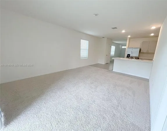 a view of empty room with kitchen