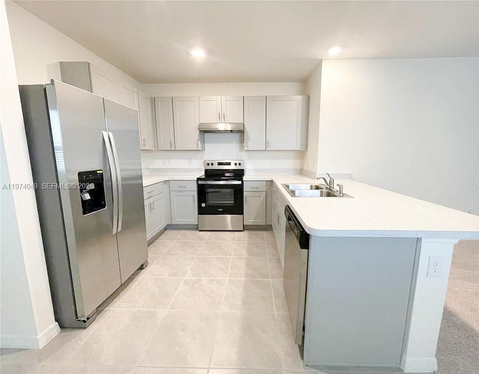 1556 Gladewater Road, Unit 1556 Kissimmee, FL 34744 - Photo 3 of 26 a kitchen with stainless steel appliances a refrigerator a sink a stove a microwave and island