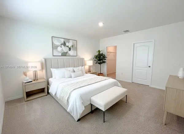 a bedroom with a bed and a painting on the wall