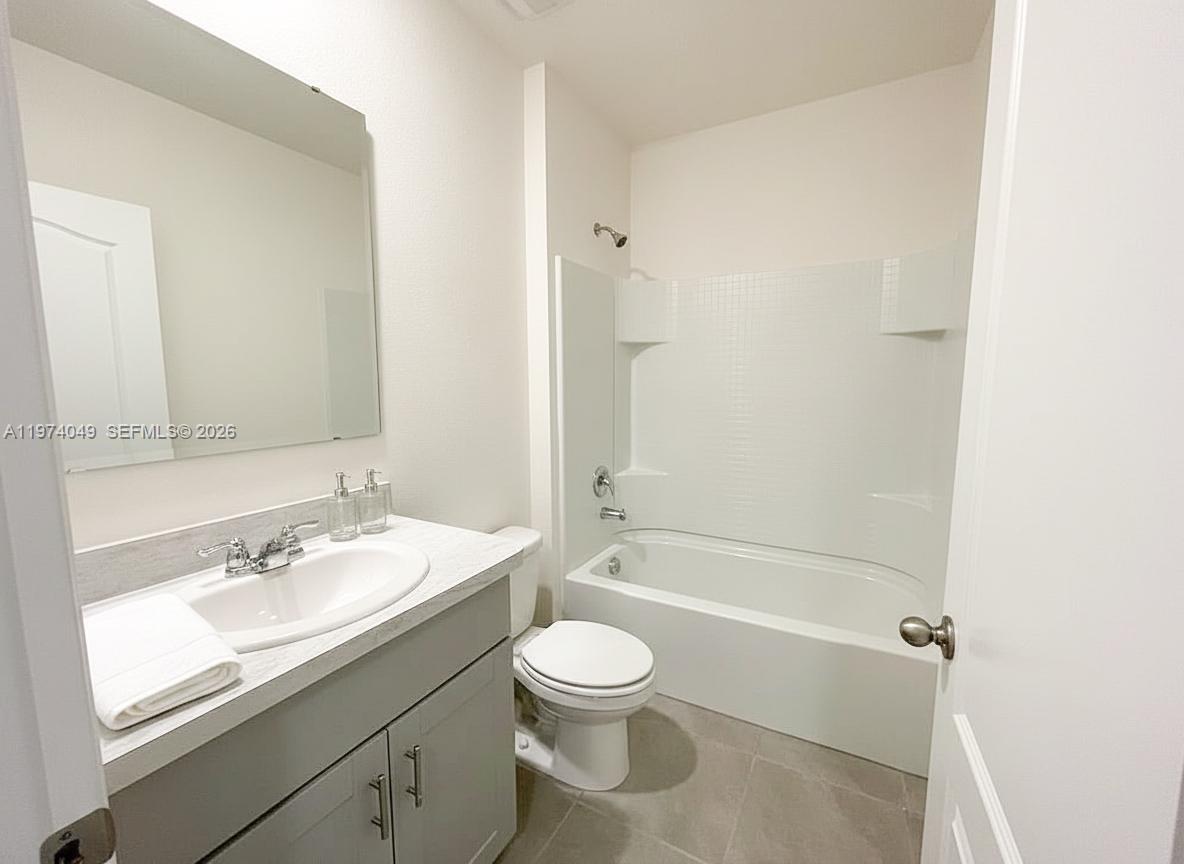 1556 Gladewater Road, Unit 1556 Kissimmee, FL 34744 - Photo 7 of 26 a bathroom with a sink a toilet and shower