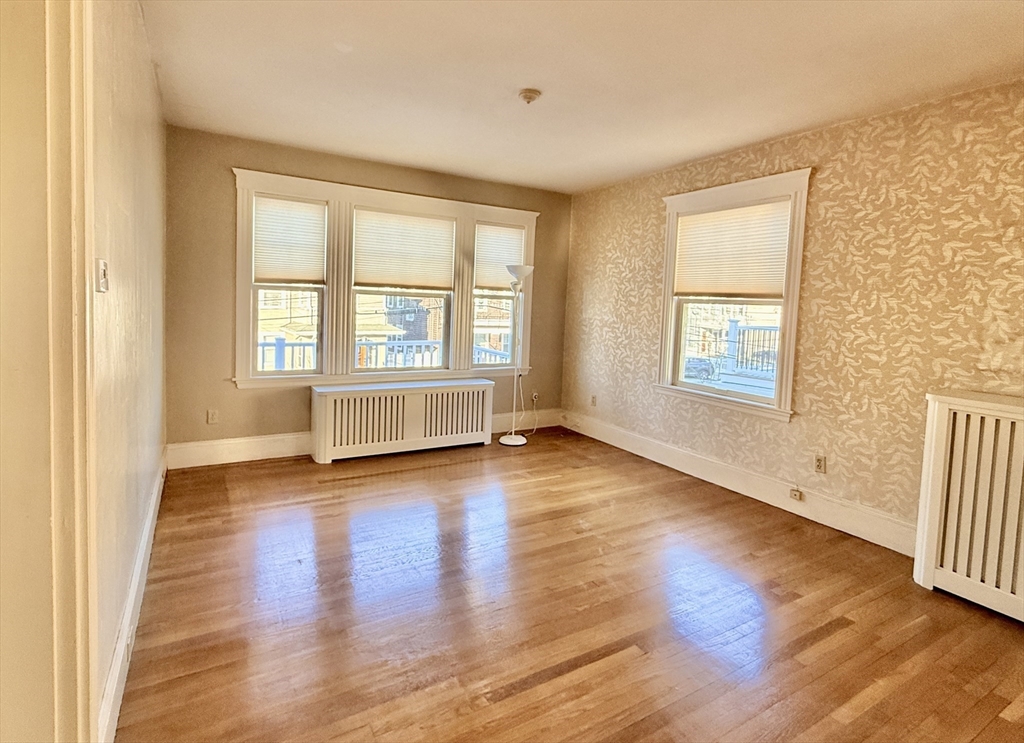 15 Belvoir Road, Unit 2 Milton, MA 02186 - Photo 2 of 13 an empty room with wooden floor and windows