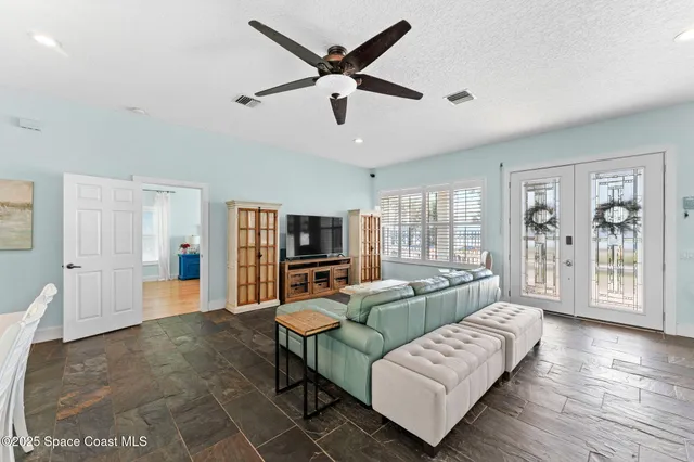 a bedroom with a bed chandelier and a window