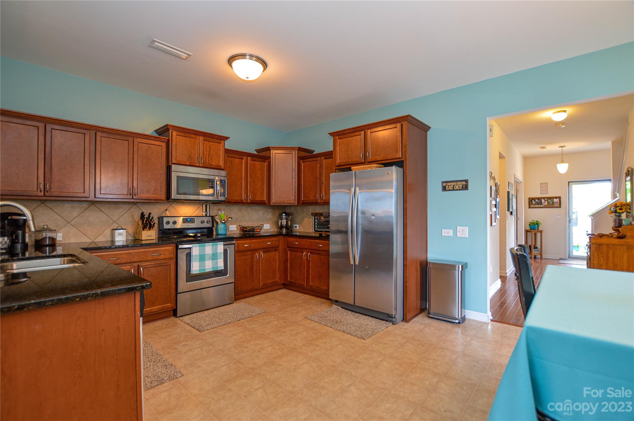 8191 Thornton Street Locust, NC 28097 - Photo 16 of 44 a kitchen with stainless steel appliances granite countertop a refrigerator a stove top oven a sink and dishwasher