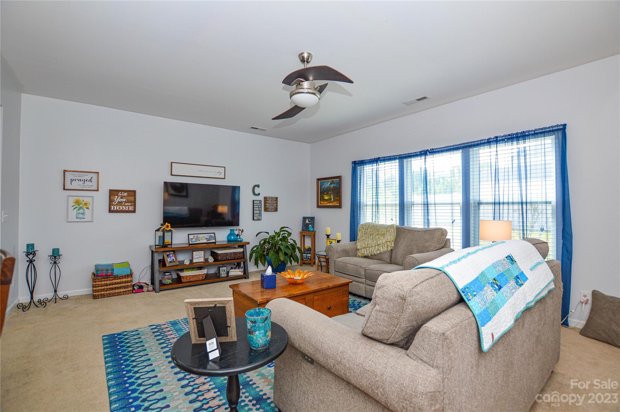 8191 Thornton Street Locust, NC 28097 - Photo 24 of 44 a living room with furniture a flat screen tv and a large window