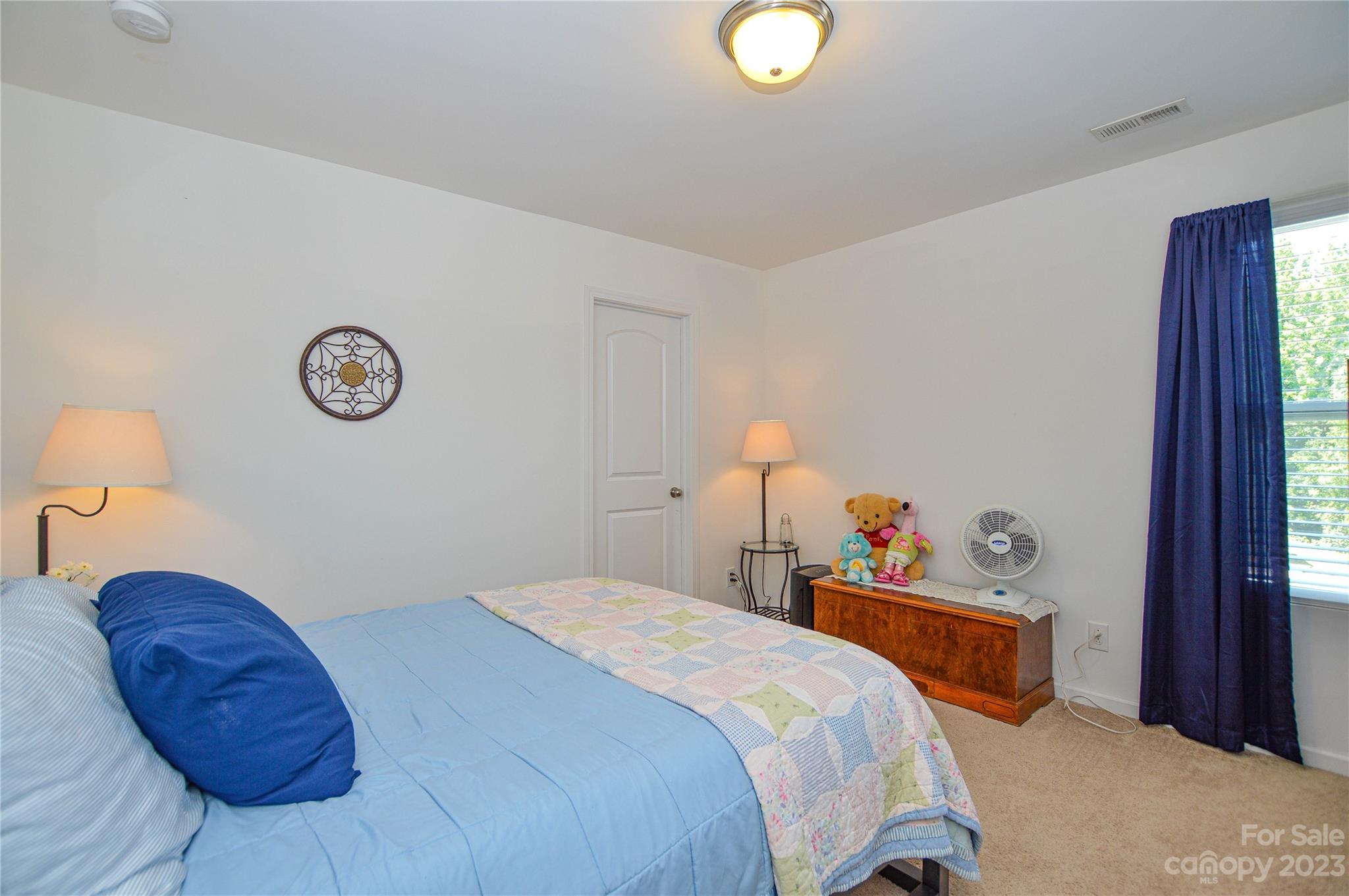 8191 Thornton Street Locust, NC 28097 - Photo 30 of 44 a bedroom with a bed and a chandelier