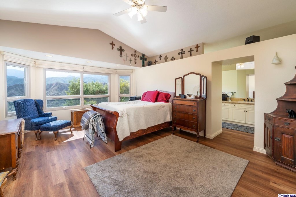 24718 Sagecrest Circle Newhall, CA 91381 - Photo 31 of 36 a spacious bedroom with a bed a couch and large windows