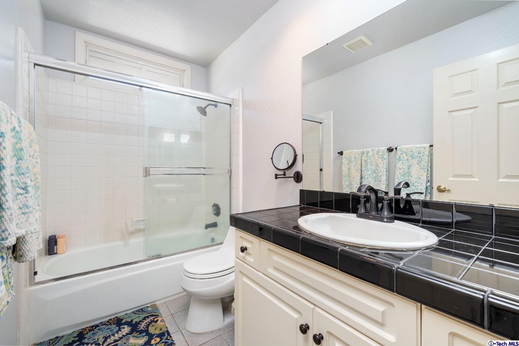 24718 Sagecrest Circle Newhall, CA 91381 - Photo 36 of 36 a bathroom with a granite countertop sink toilet a mirror and shower
