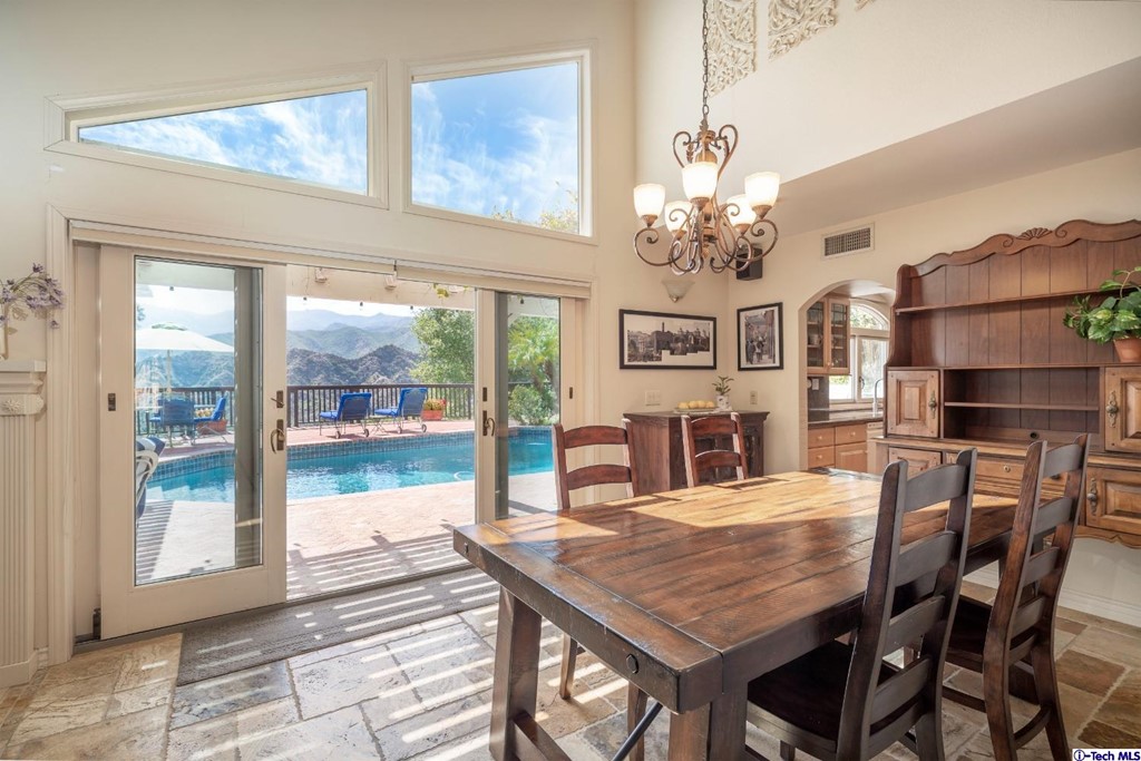 24718 Sagecrest Circle Newhall, CA 91381 - Photo 6 of 36 a dining room with wooden floor a chandelier a wooden table and chairs