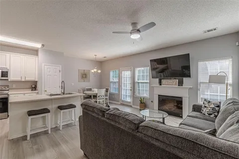a living room with furniture a flat screen tv and a fireplace