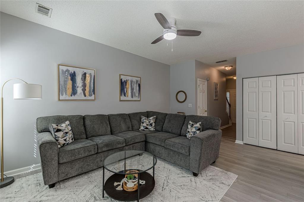 7640 Rutgers Circle Fairburn, GA 30213 - Photo 14 of 49 a living room with furniture and a wooden floor