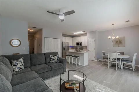 a view of a dining room and livingroom with furniture wooden floor a chandelier