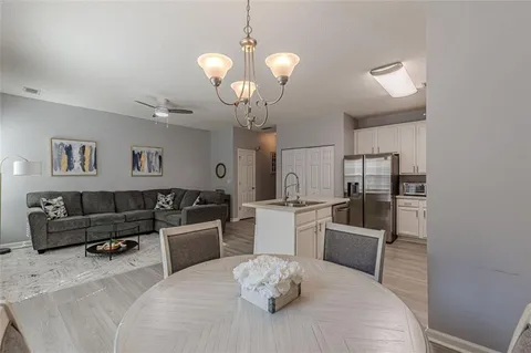 a dining room with furniture a chandelier and wooden floor