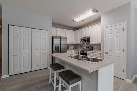 a kitchen with granite countertop white cabinets and a stove top oven