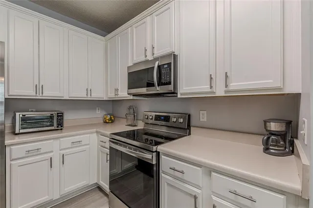 a kitchen with a stove a sink a dining table and chairs