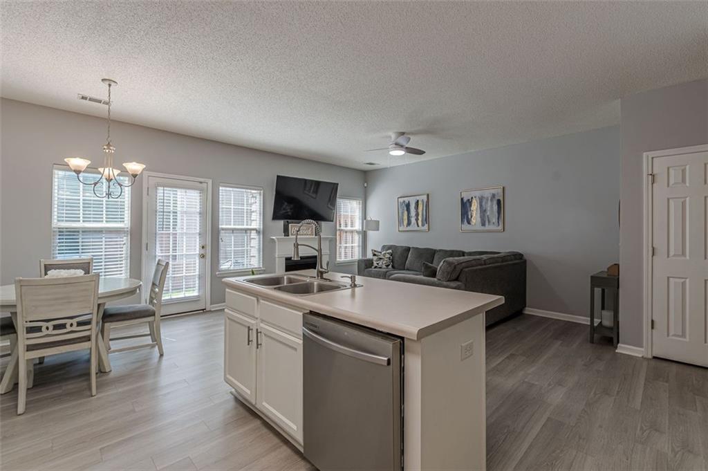 7640 Rutgers Circle Fairburn, GA 30213 - Photo 23 of 49 a kitchen with a stove a sink a dining table and chairs