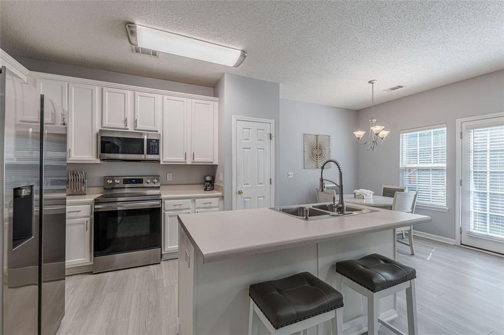 7640 Rutgers Circle Fairburn, GA 30213 - Photo 24 of 49 a kitchen with a sink cabinets and stainless steel appliances