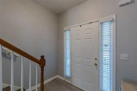 a view of a hallway with wooden floor and stairs