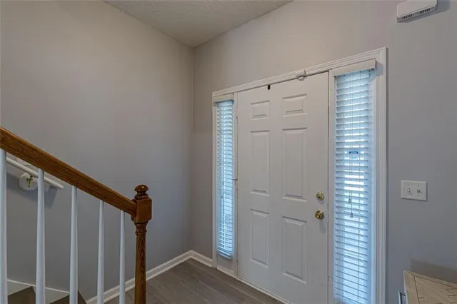 a view of a hallway with wooden floor and stairs