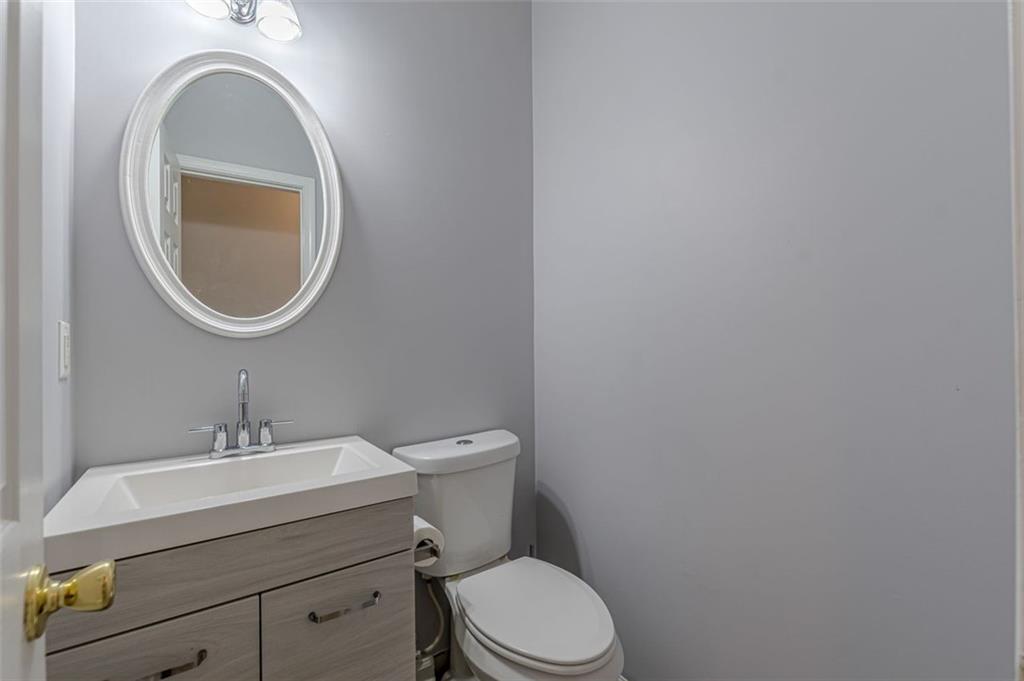 7640 Rutgers Circle Fairburn, GA 30213 - Photo 10 of 49 a bathroom with a toilet a sink and mirror