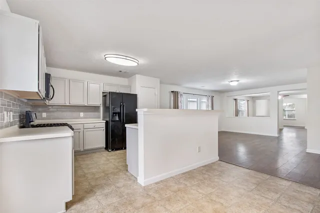 a kitchen with a refrigerator and a stove top oven