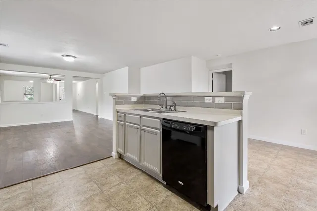 a kitchen with a sink dishwasher a stove and a microwave oven with cabinets