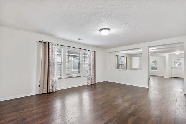 an empty room with wooden floor and cabinet