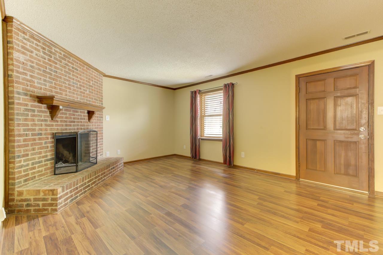 5505 Hamstead Crossing Raleigh, NC 27612 - Photo 3 of 25 a view of empty room with wooden floor and fireplace