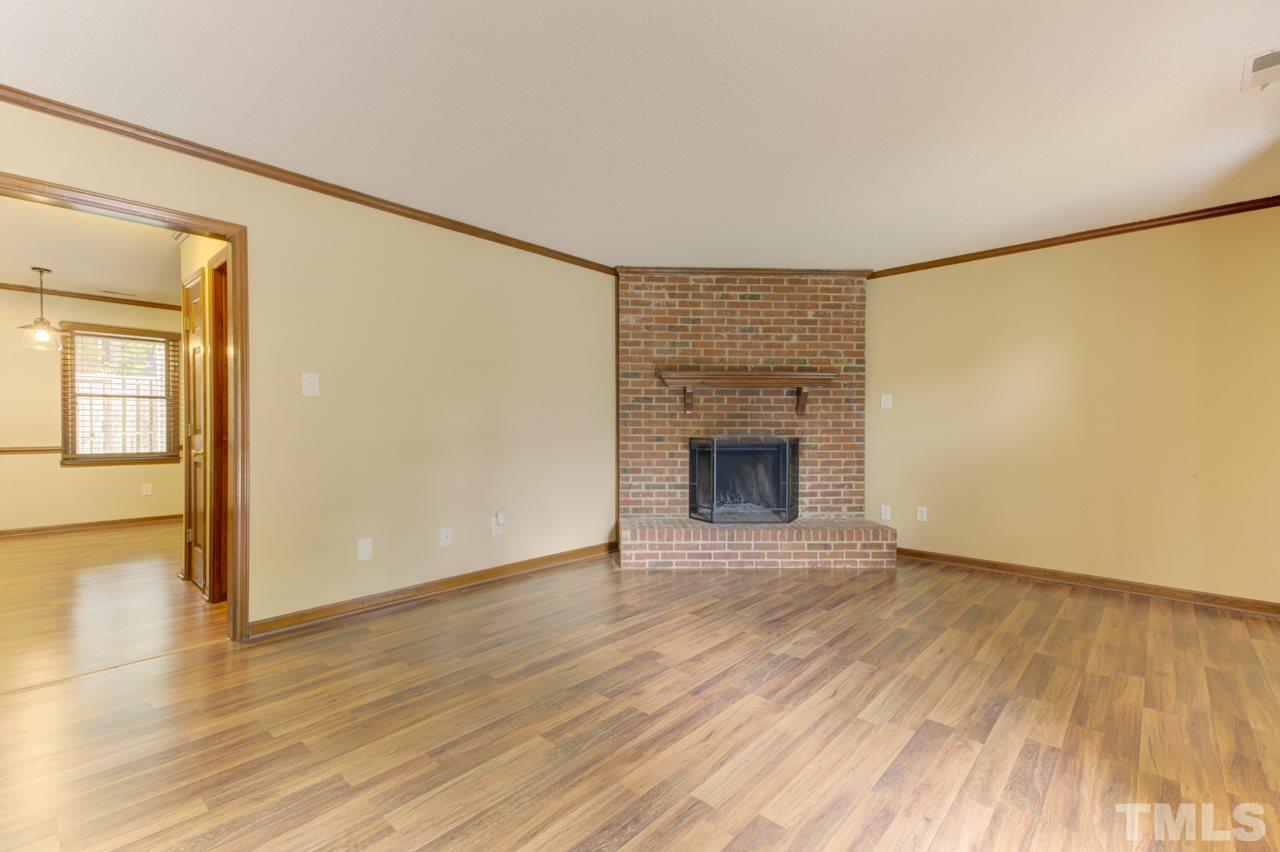 5505 Hamstead Crossing Raleigh, NC 27612 - Photo 4 of 25 a view of an empty room with wooden floor and a fireplace