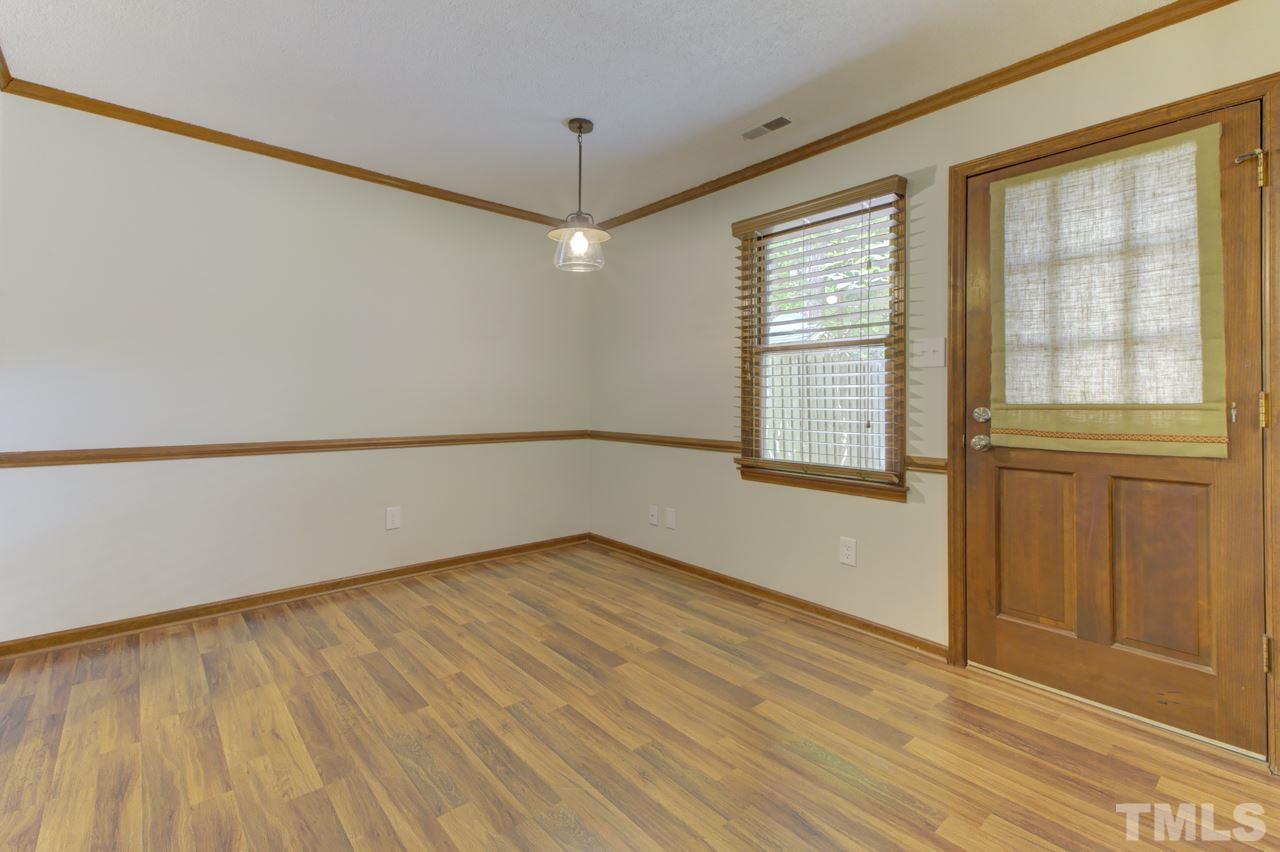 5505 Hamstead Crossing Raleigh, NC 27612 - Photo 7 of 25 an empty room with wooden floor and windows