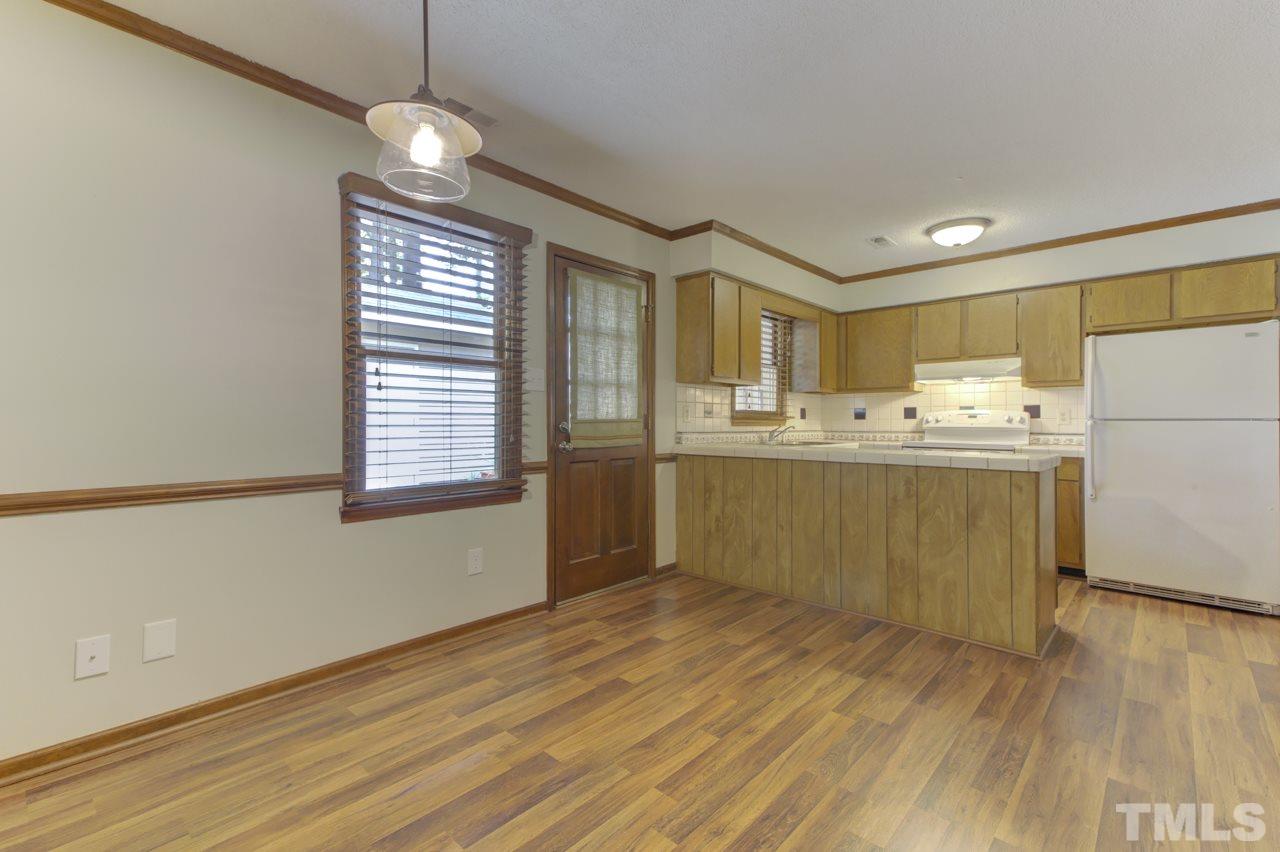 5505 Hamstead Crossing Raleigh, NC 27612 - Photo 8 of 25 a kitchen with stainless steel appliances a sink a stove a refrigerator cabinets and wooden floor