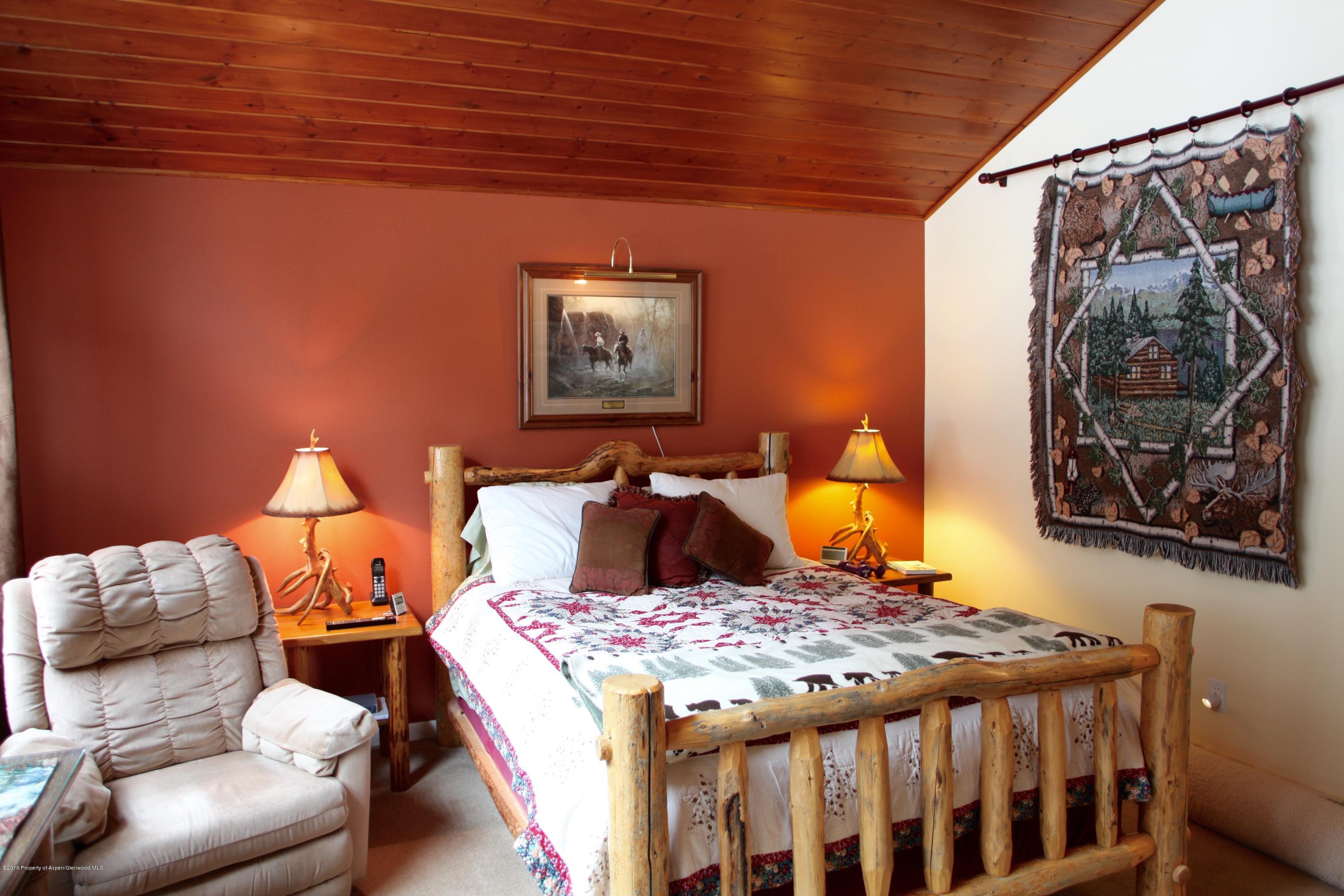 450 Redstone Boulevard Redstone, CO 81623 - Photo 9 of 16 a bed sitting in a bedroom next to a lamp