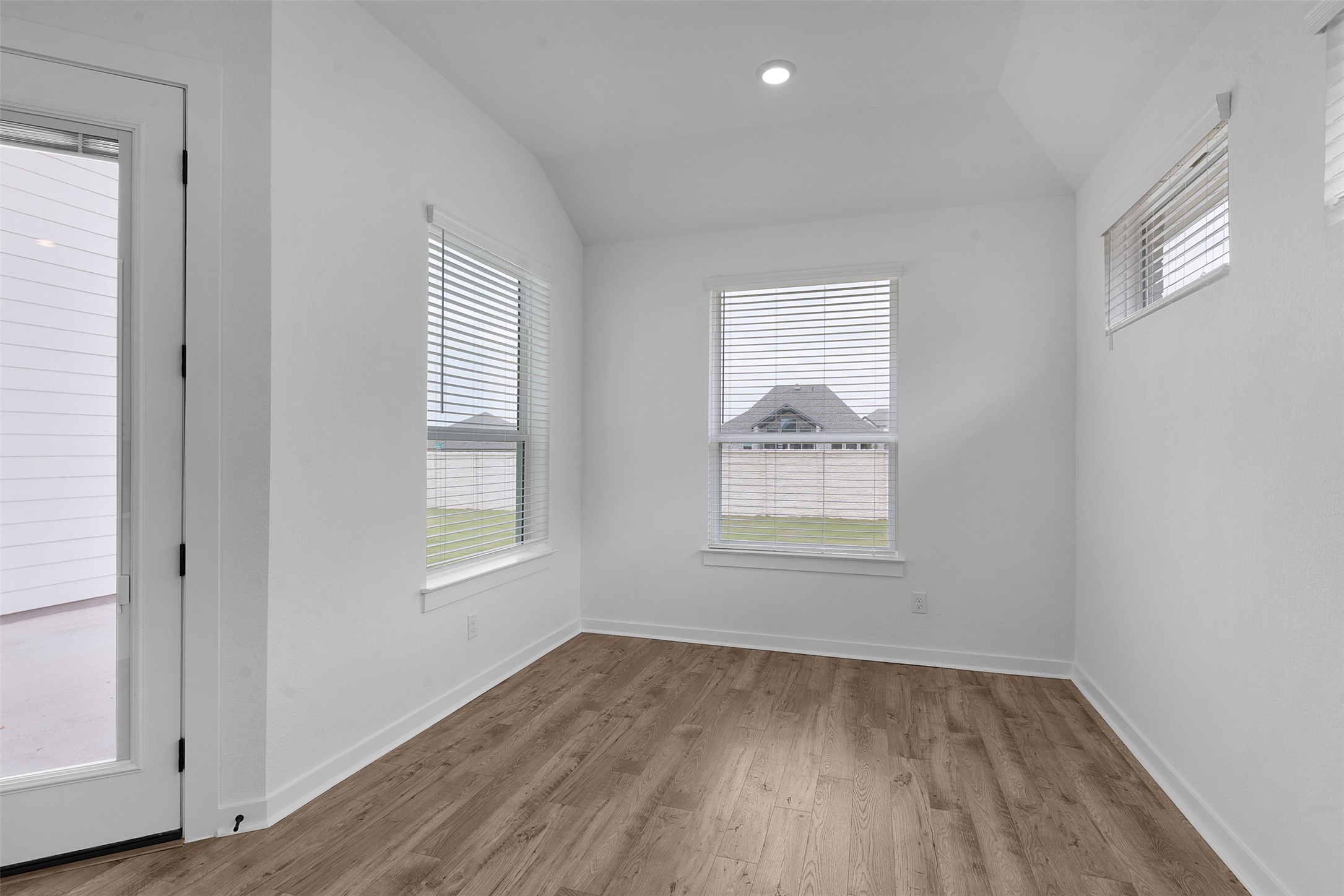 19504 Domino Champ Road Pflugerville, TX 78660 - Photo 12 of 24 Spare room featuring vaulted ceiling, wood finished floors, healthy amount of natural light, and recessed lighting