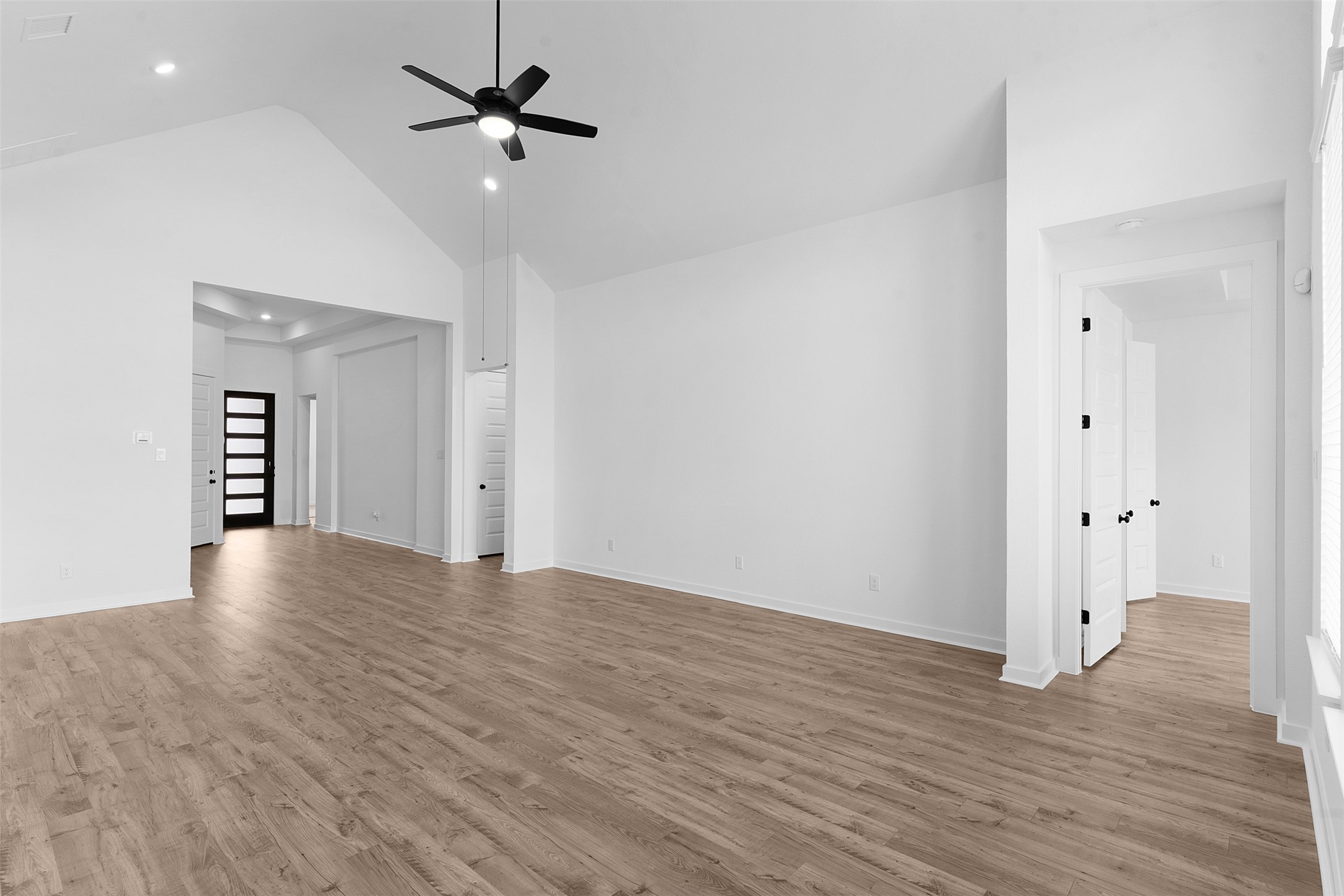 19504 Domino Champ Road Pflugerville, TX 78660 - Photo 13 of 24 Unfurnished living room featuring a ceiling fan, vaulted ceiling, light wood-style flooring, and recessed lighting