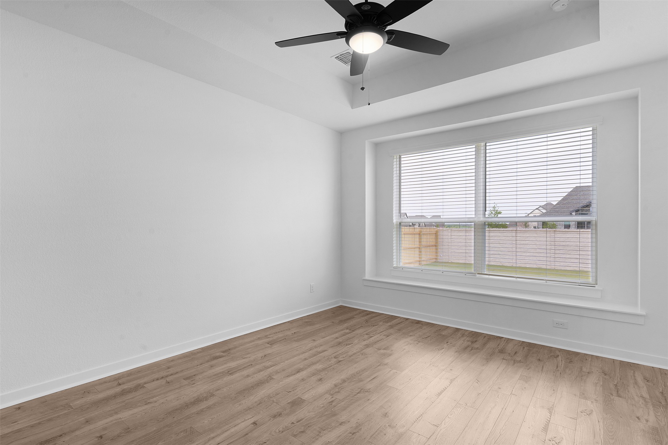 19504 Domino Champ Road Pflugerville, TX 78660 - Photo 14 of 24 Spare room featuring a raised ceiling, wood finished floors, and a ceiling fan