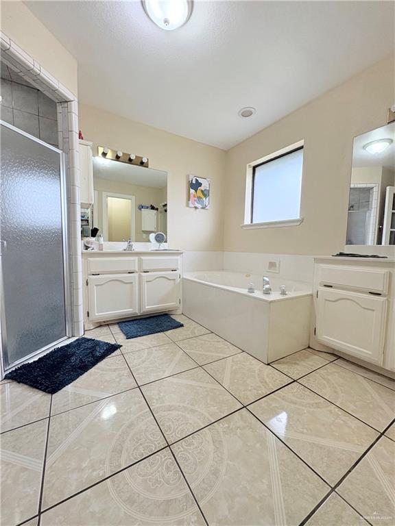 2218 Lawndale Road Mission, TX 78572 - Photo 11 of 24 Bathroom featuring a garden tub, vanity, tile patterned flooring, and a stall shower
