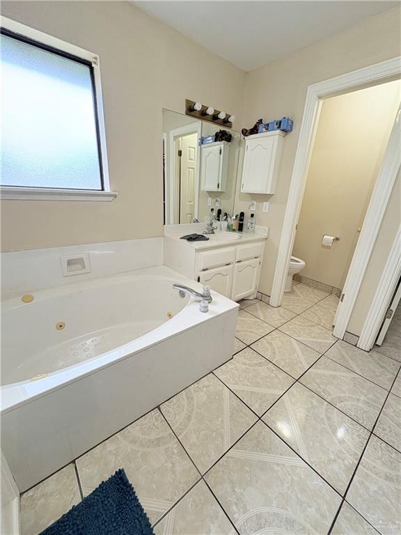 2218 Lawndale Road Mission, TX 78572 - Photo 12 of 24 Bathroom featuring tile patterned flooring, a jetted tub, toilet, and vanity