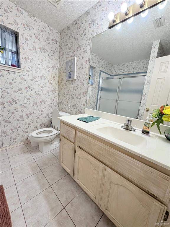 2218 Lawndale Road Mission, TX 78572 - Photo 20 of 24 Bathroom with toilet, a stall shower, visible vents, wallpapered walls, and tile patterned flooring