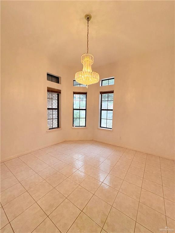2218 Lawndale Road Mission, TX 78572 - Photo 4 of 24 Spare room featuring light tile patterned flooring, a chandelier, and a high ceiling