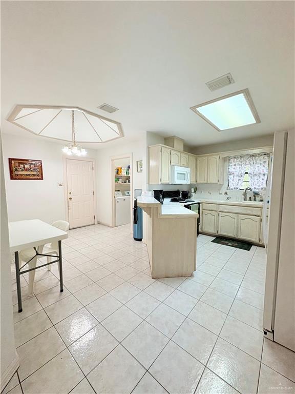 2218 Lawndale Road Mission, TX 78572 - Photo 5 of 24 Kitchen featuring a peninsula, visible vents, white appliances, light countertops, and light tile patterned floors