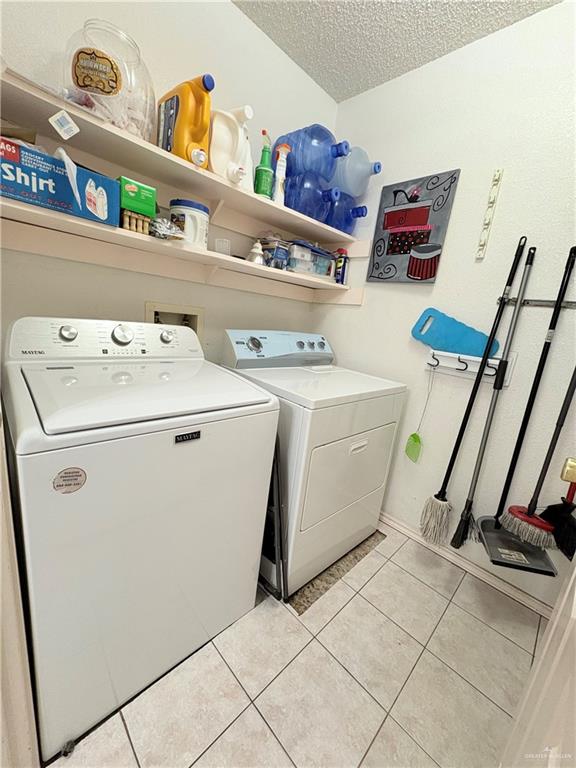 2218 Lawndale Road Mission, TX 78572 - Photo 7 of 24 Laundry area with independent washer and dryer, a textured ceiling, laundry area, and light tile patterned floors