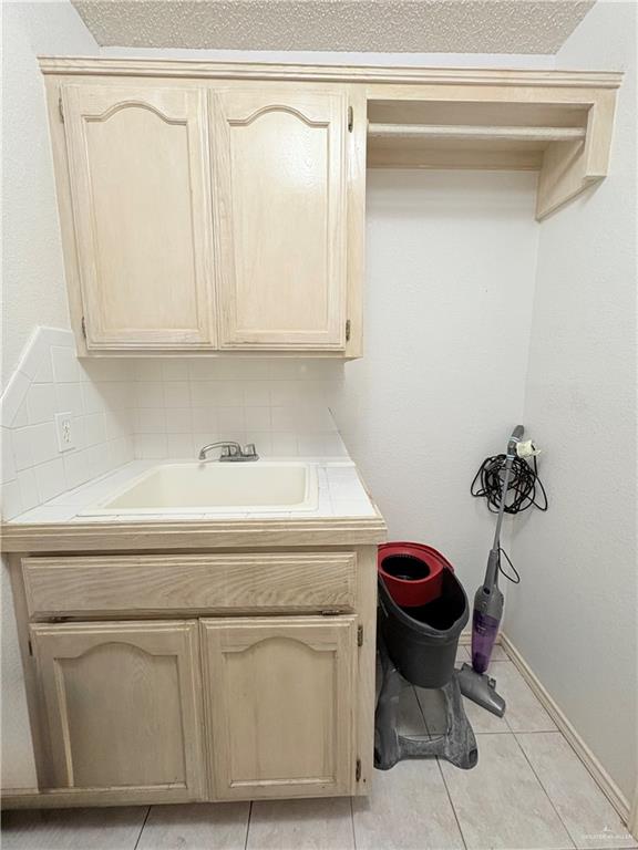 2218 Lawndale Road Mission, TX 78572 - Photo 8 of 24 Laundry area with baseboards, a sink, and light tile patterned floors